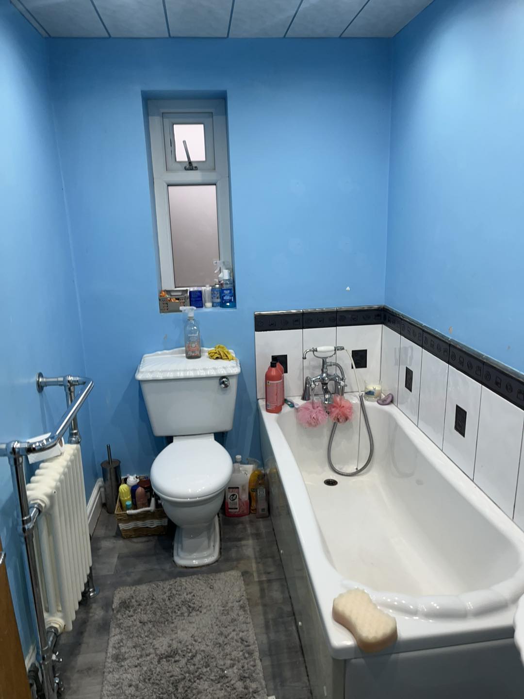Bathroom before — bright blue walls and ceiling, dated tiles