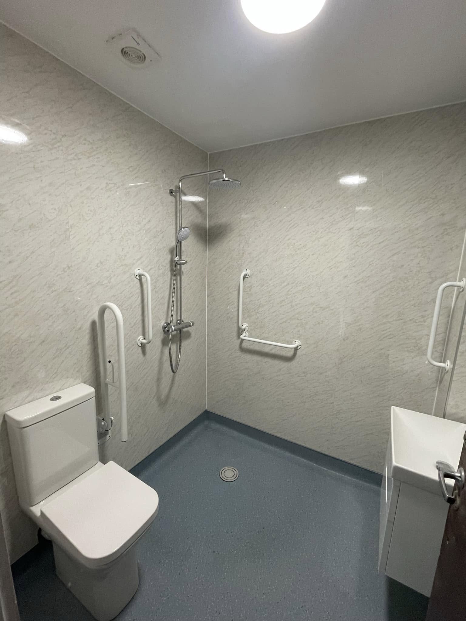 Accessible wet room after — non-slip floor, grab rails, level-access shower