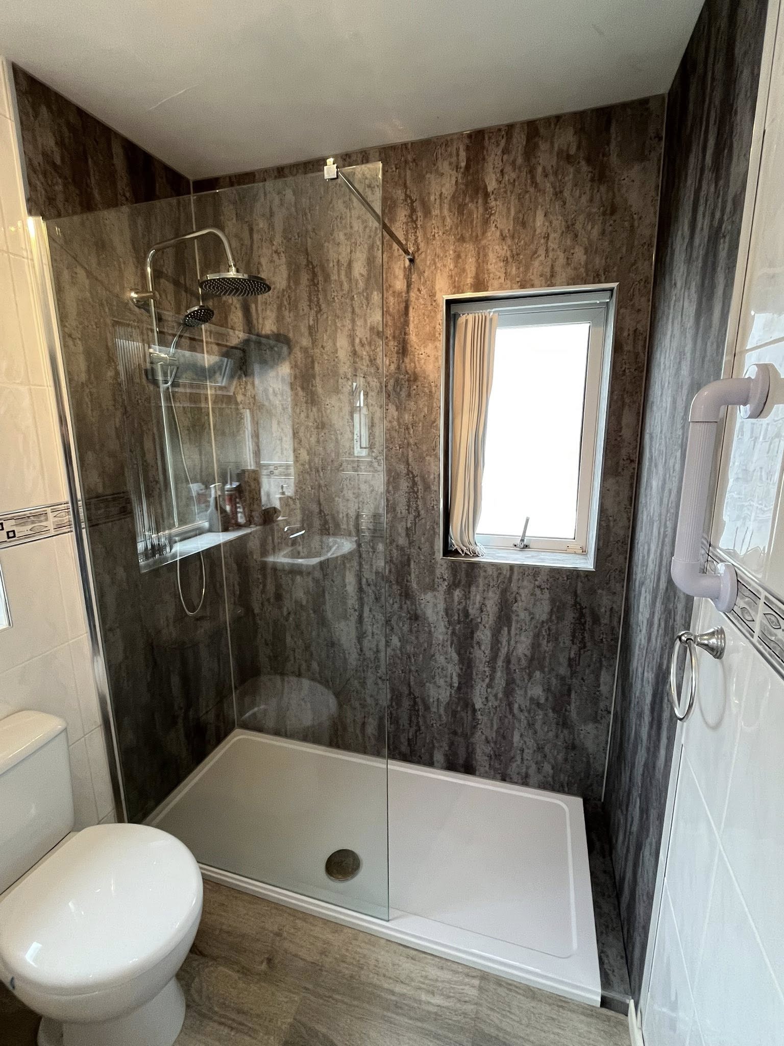Mobility shower after — walk-in with stone-effect panels and rain shower